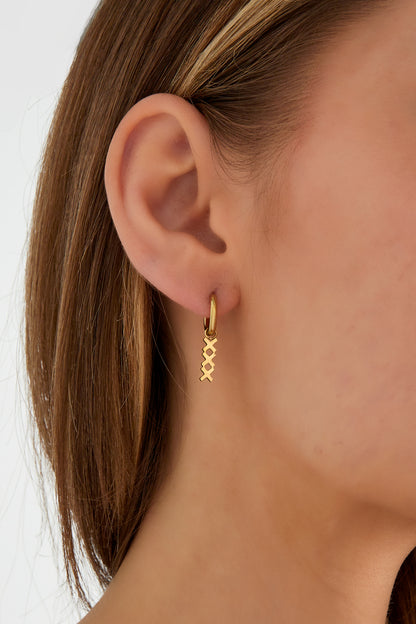 Close-up of a woman wearing the gold geometric hoop drop earring showing the delicate design