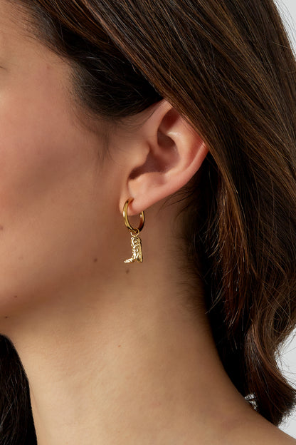 Model wearing gold cowgirl boot charm hoop earrings with close-up on ear
