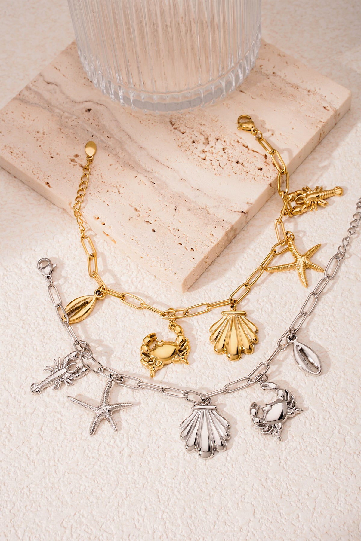 Gold-tone seaside charm bracelet displayed on black premium product line card