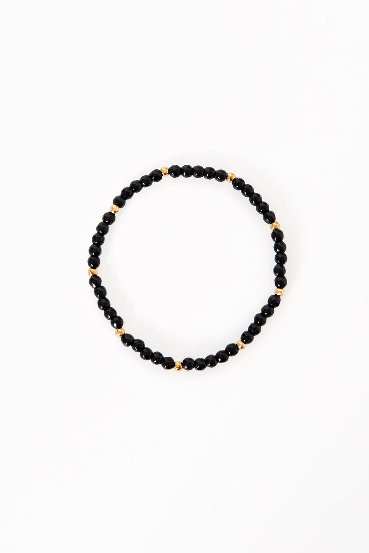 Black and gold beaded bracelet laid flat on white background showcasing small glossy black beads and gold accent beads