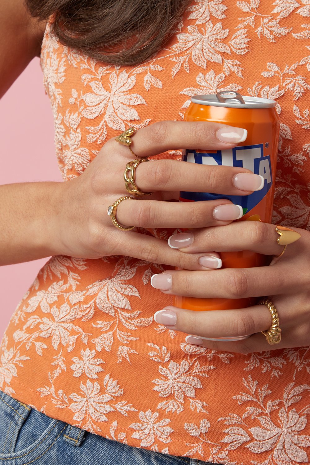 Gold chain link ring featuring a textured, interlocking design, worn on a hand holding an orange soda can.