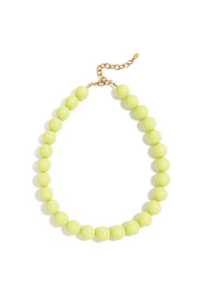 Chunky beaded necklace featuring vibrant lime-green round beads and a gold-tone chain clasp on a white background.