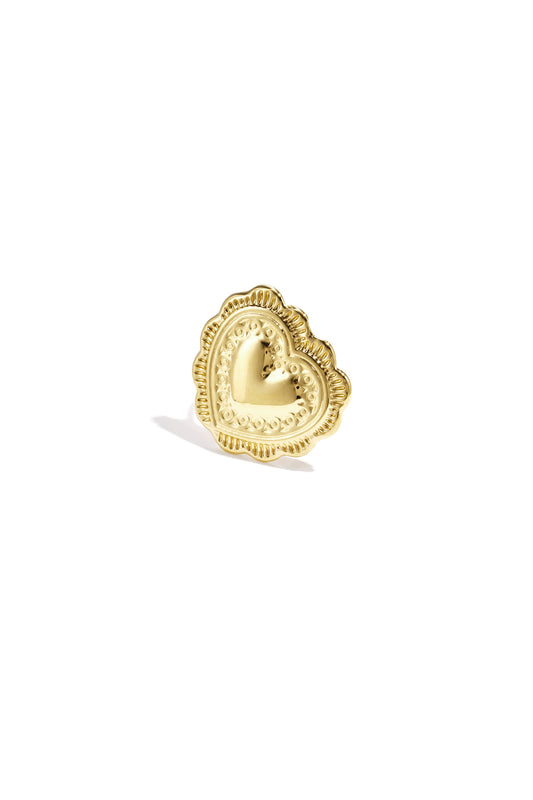Close-up of a gold heart-shaped statement ring with detailed scalloped edges on white background