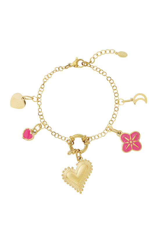 Gold-plated charm bracelet laid flat with four detachable charms: heart, pink enamel heart, pink flower, and crescent moon, shown on white background