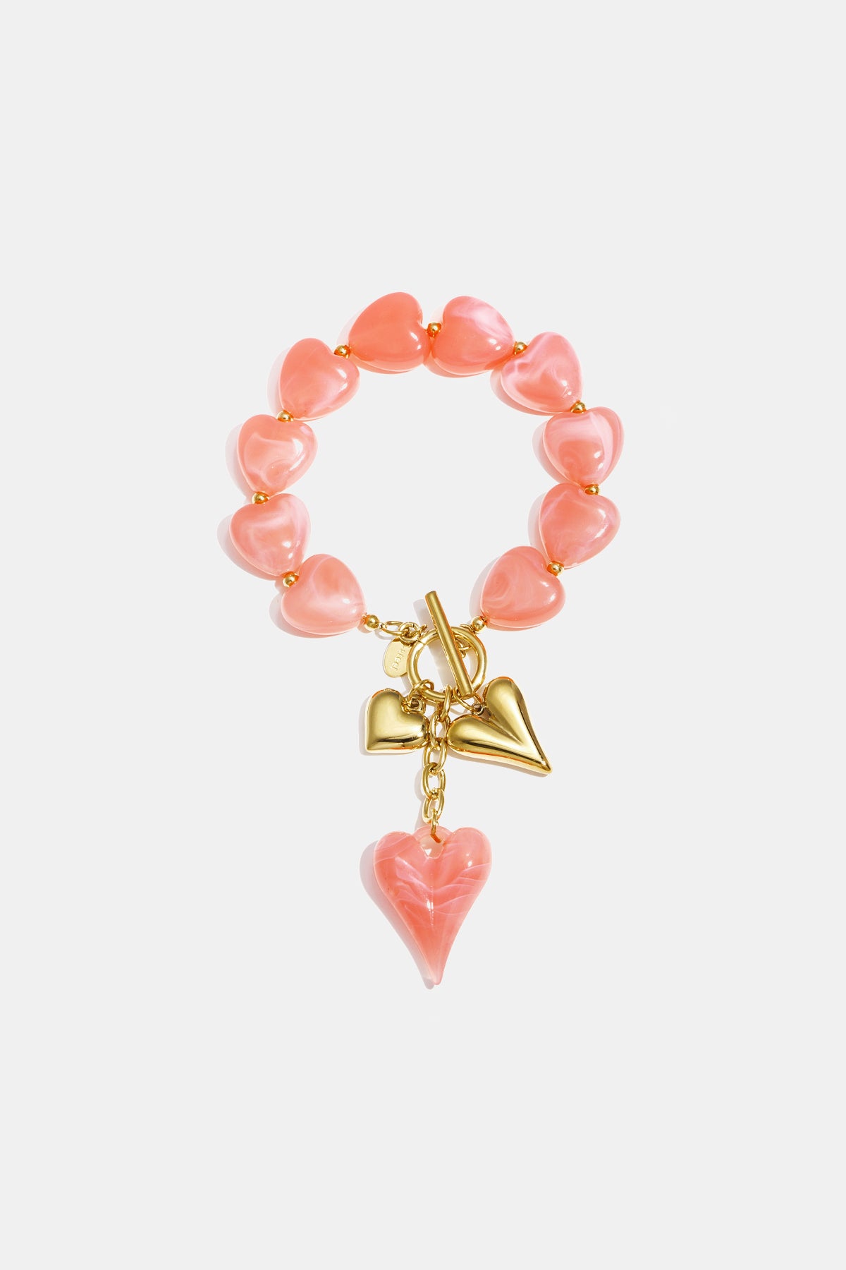 Close-up of blush pink heart-shaped acrylic beaded bracelet featuring gold heart charms and toggle clasp on white background