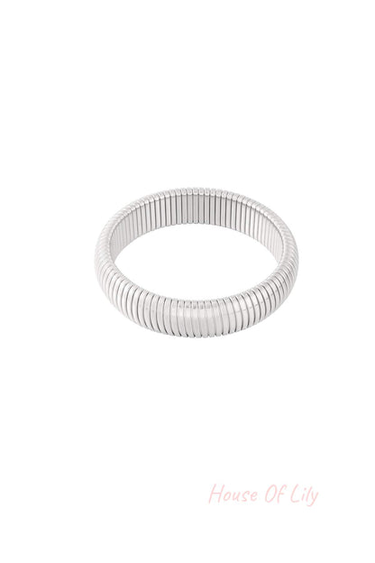 Side view of the gold stretch bracelet highlighting smooth segmented design and polish