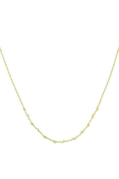 Yellow and turquoise knotted cotton necklace with gold accents laid flat on white background