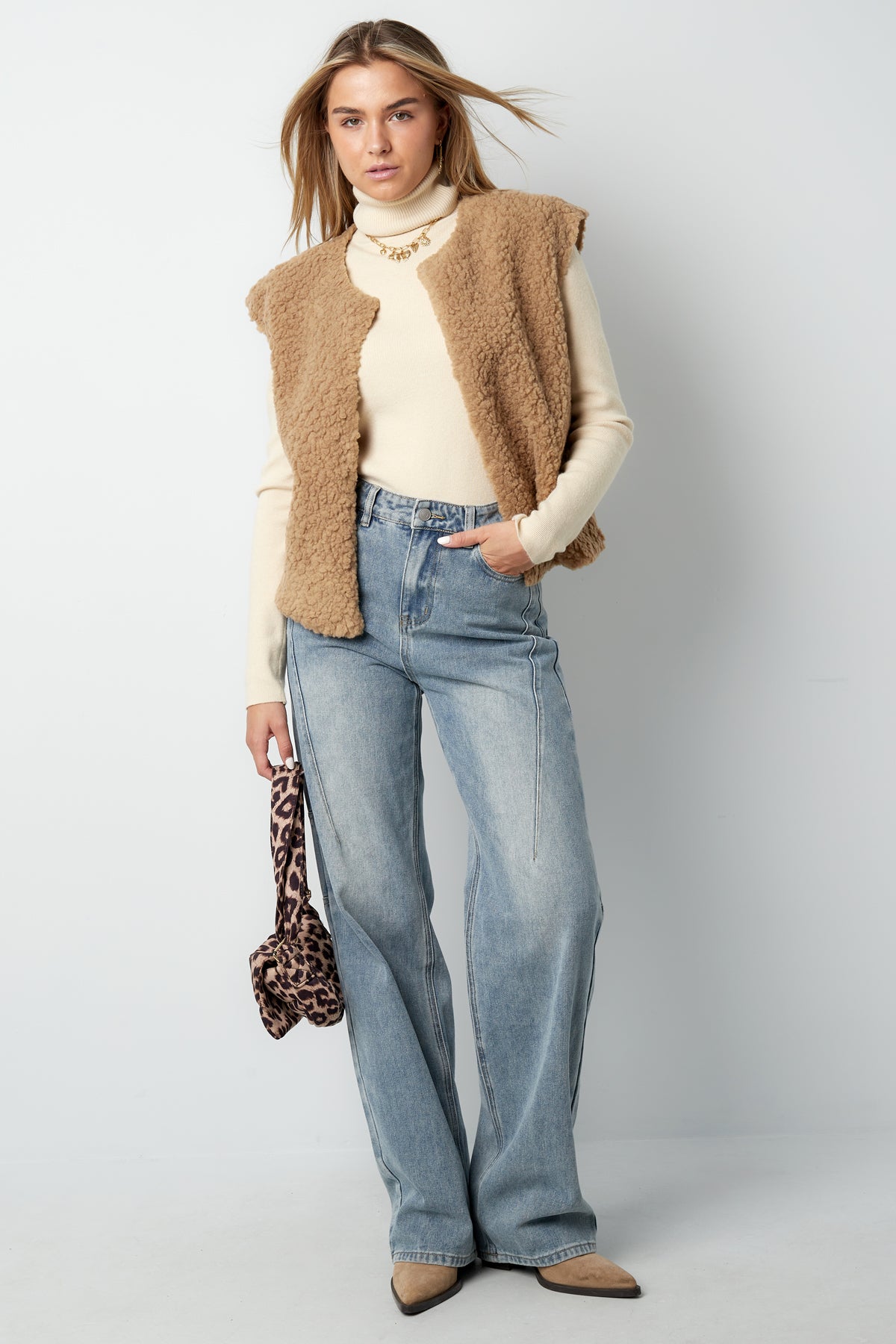 Back view of off-white sherpa vest on white background showing plush texture and simple cut