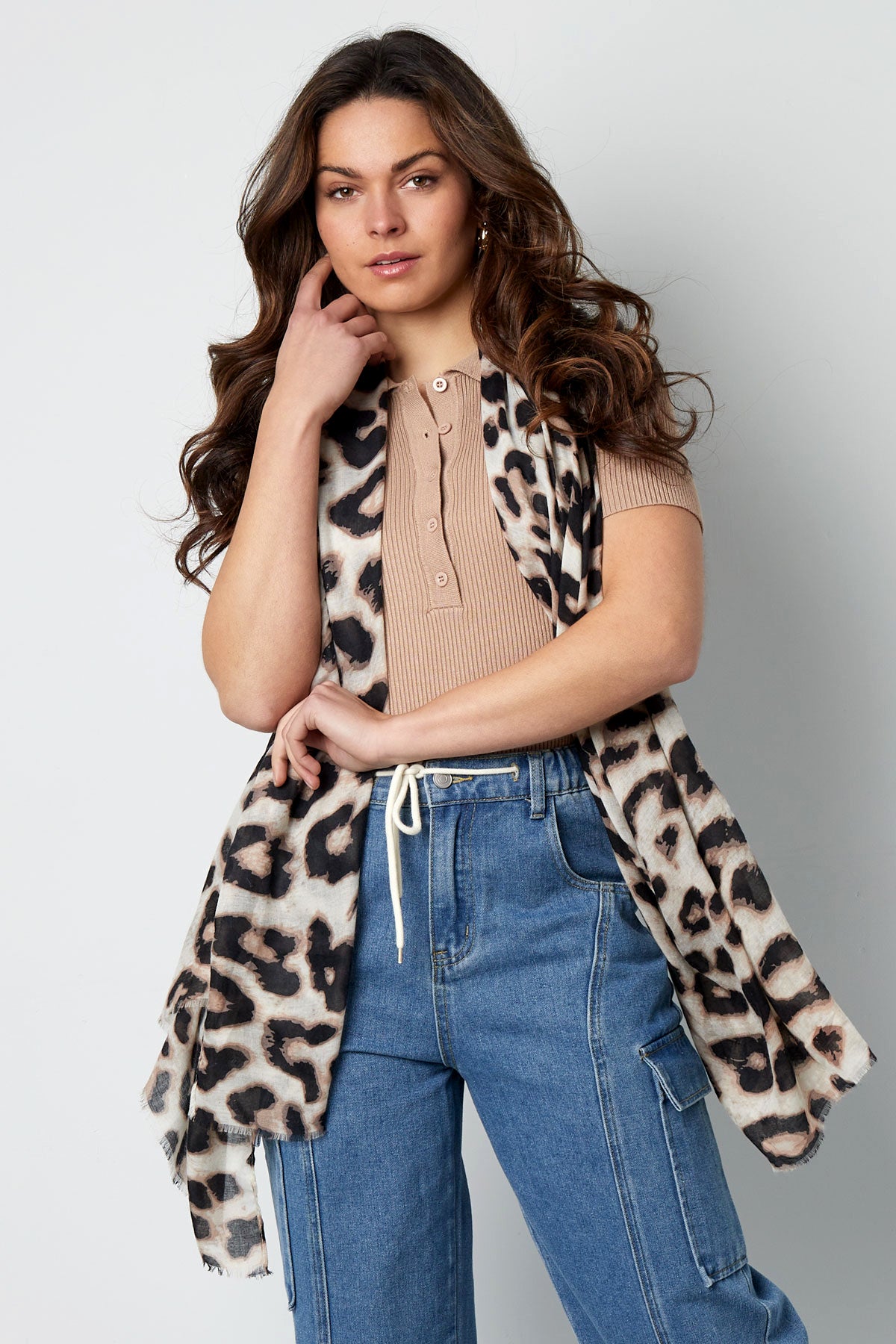 Woman modeling leopard print scarf draped gracefully over shoulders with casual outfit