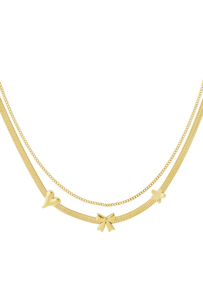 Gold layered charm necklace with heart, bow, and flower pendants on white background