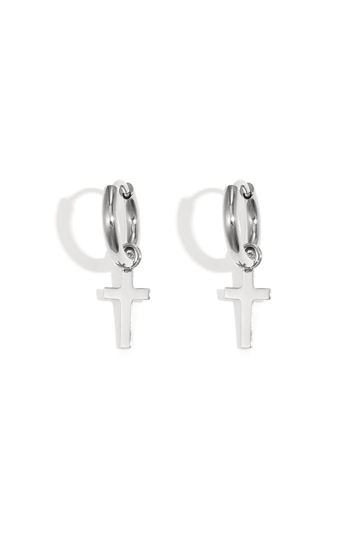 Pair of silver hoop earrings featuring delicate dangling cross pendants on a white background