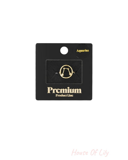 Gold ring with Aquarius constellation design on a black display card.