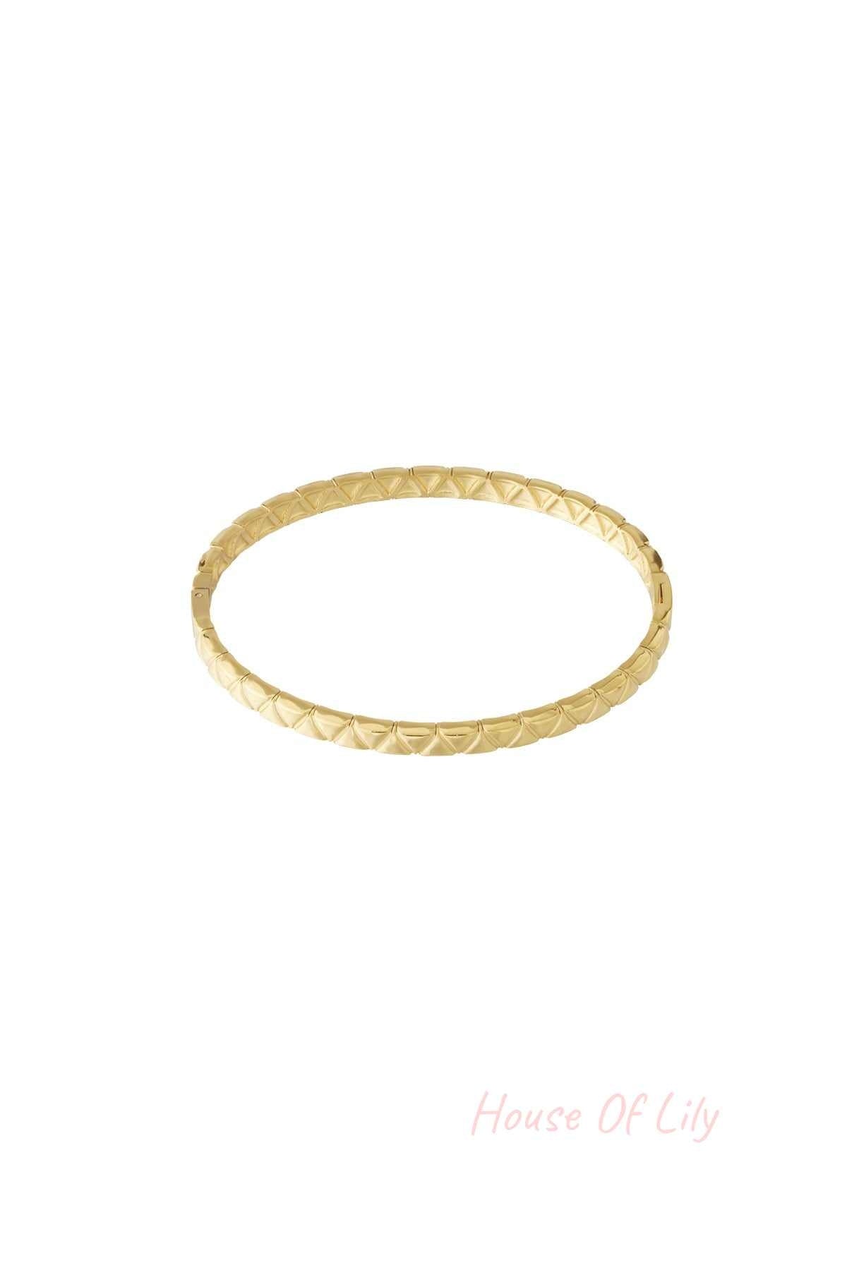Gold textured bangle with geometric pattern isolated on white background