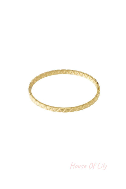 Gold textured bangle with geometric pattern isolated on white background