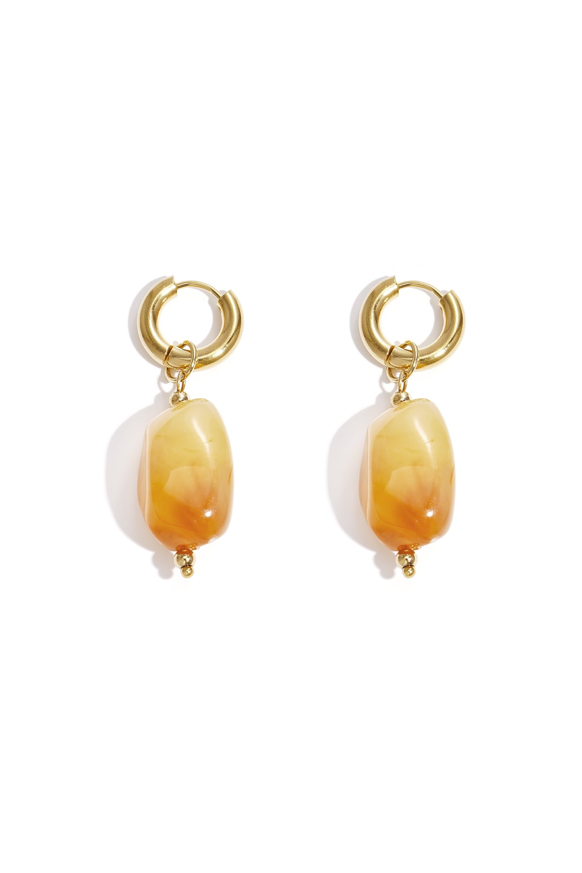 Gold hoop earrings with irregular orange resin drop beads on white background