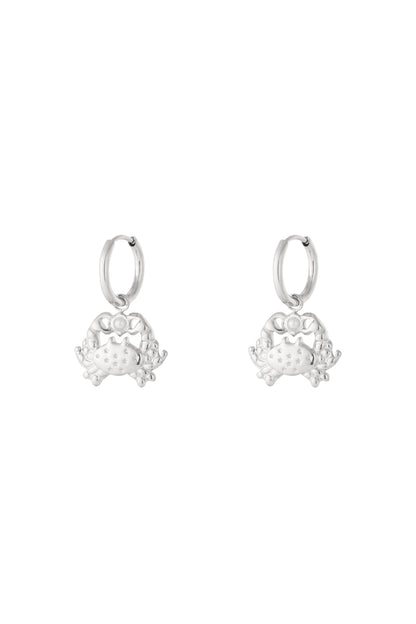 Pair of silver crab-shaped drop hoop earrings with star engravings and pearl detail.