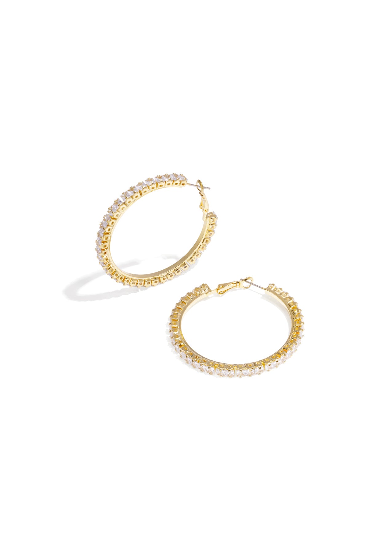 Close-up of gold-tone hoop earrings encrusted with clear crystals, displayed flat on a white background.