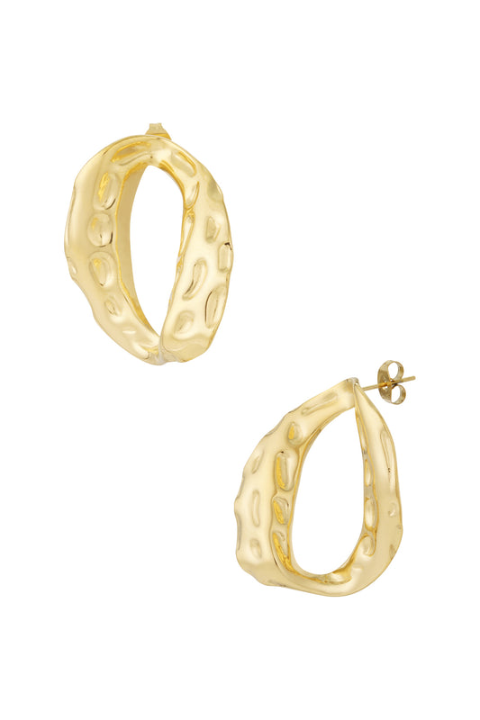 Close-up of textured gold-tone oval stud earrings with an irregular, soft hammered surface finish.
