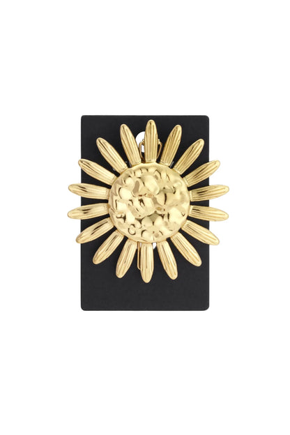 Gold-tone sunflower brooch featuring a textured center and elongated petals on a black display card.