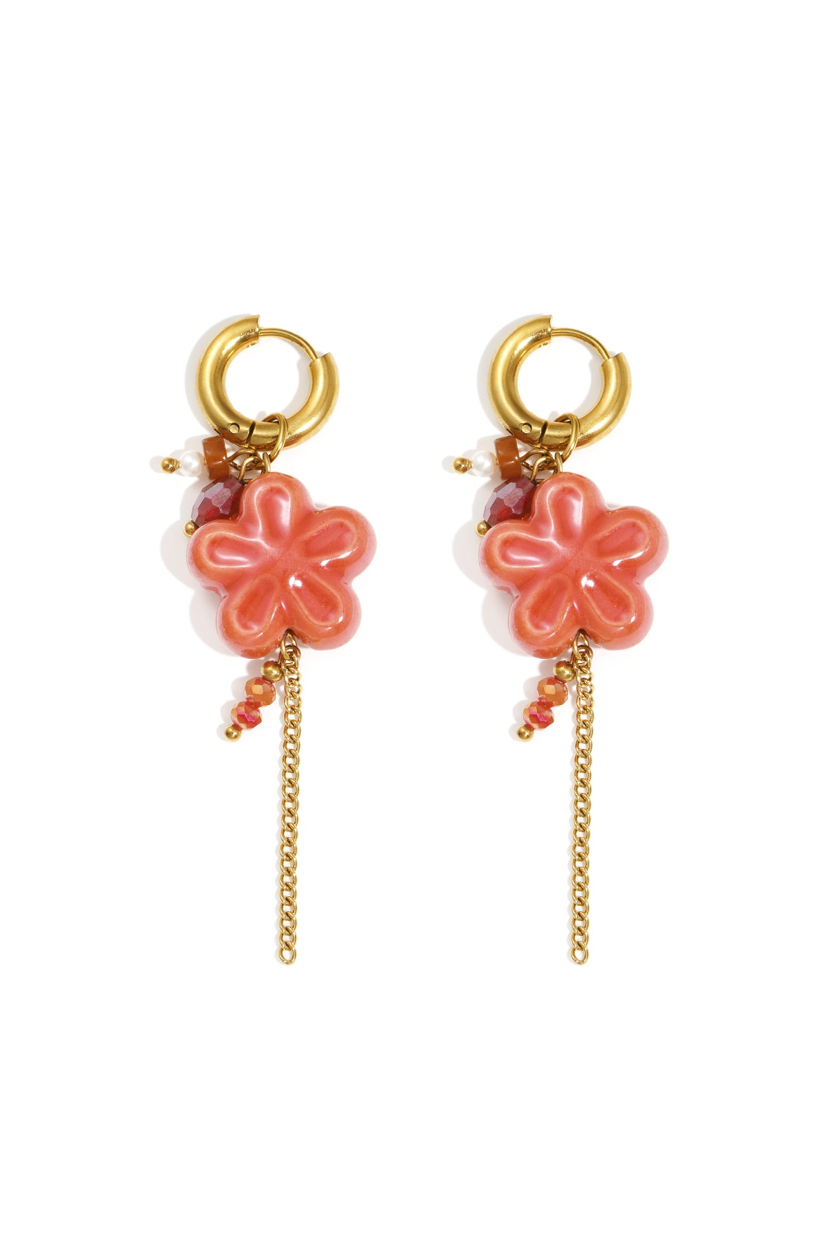 Pair of gold hoop drop earrings with coral resin flower pendants, decorated with faceted beads and delicate gold chain tassels on white background