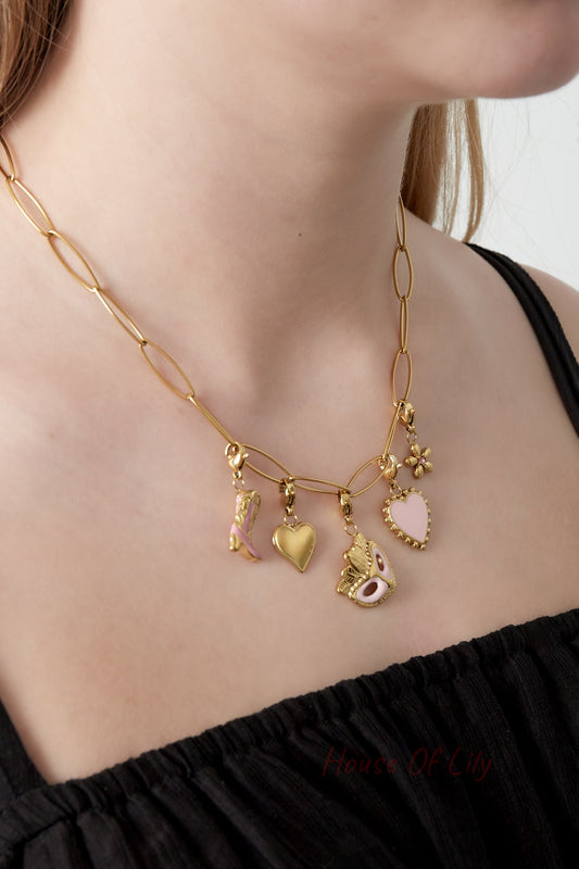 Model wearing the gold charm link necklace showcasing the playful charms against a black top