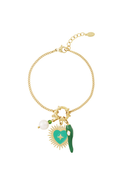 Gold charm bracelet with three charms attached - green enamel heart, pearl, and green chili pepper - laid flat on white background