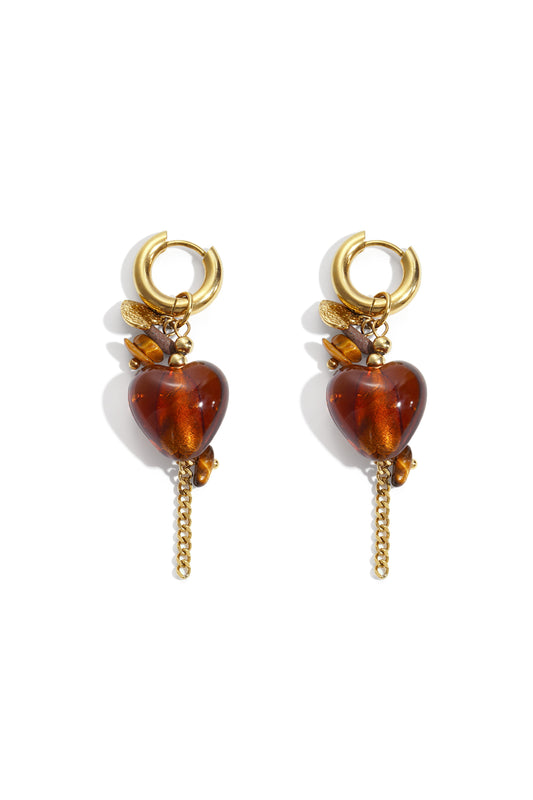 Pair of gold hoop earrings with dangling amber heart charms, decorative gold beads, and delicate gold chains