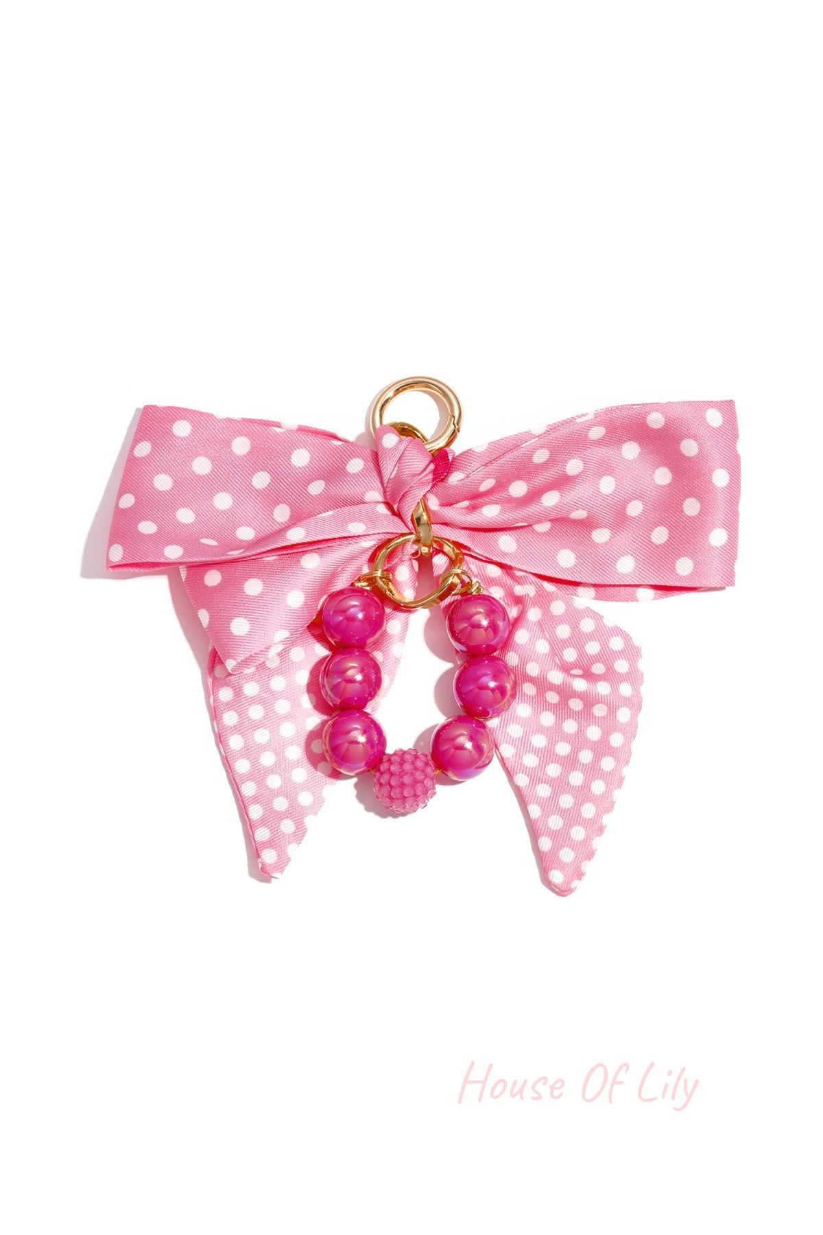 Pink polka dot fabric bow with glossy pink and textured beads bag charm attached to gold clasp