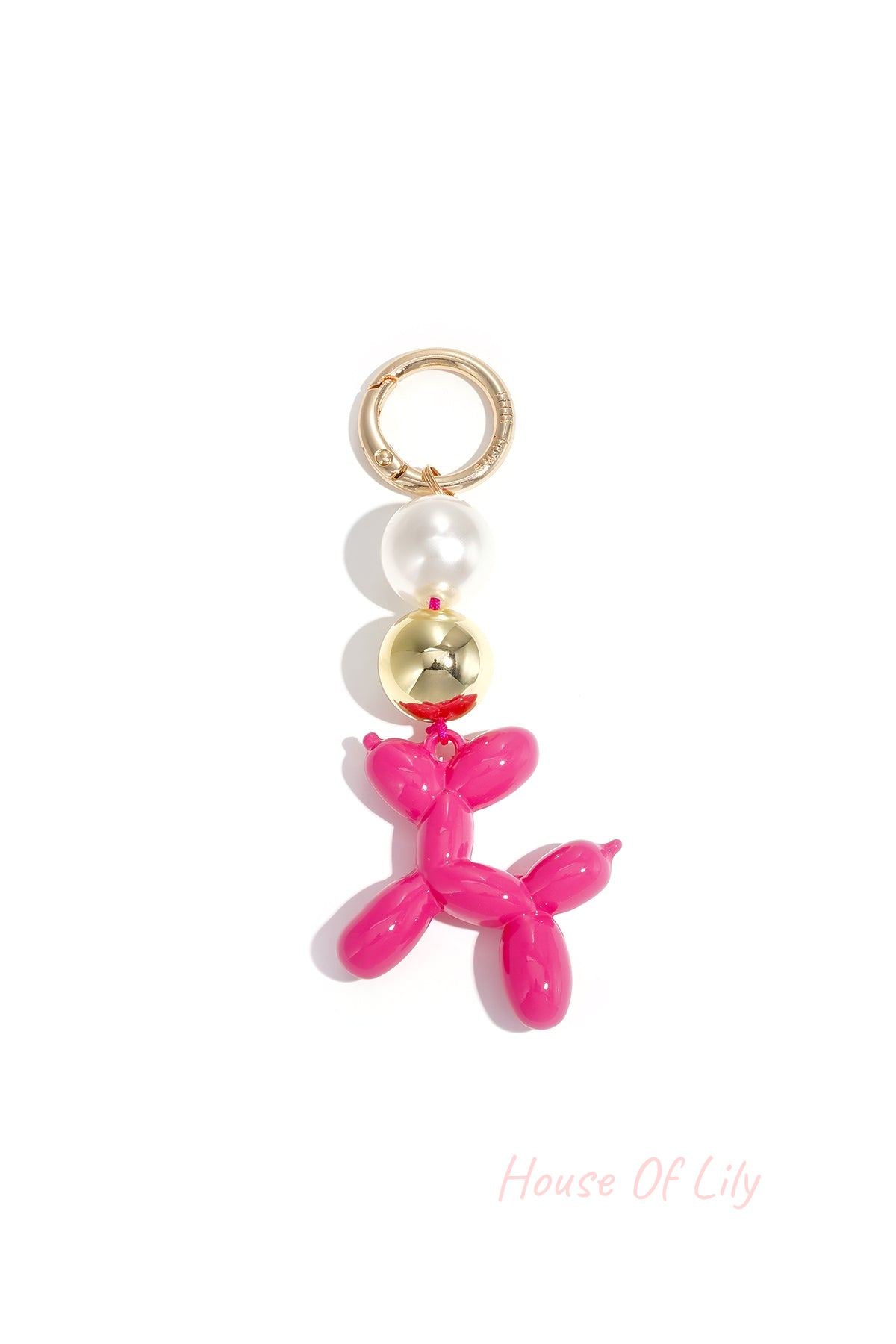 Bright pink balloon dog bag charm with pearl and gold beads on white background