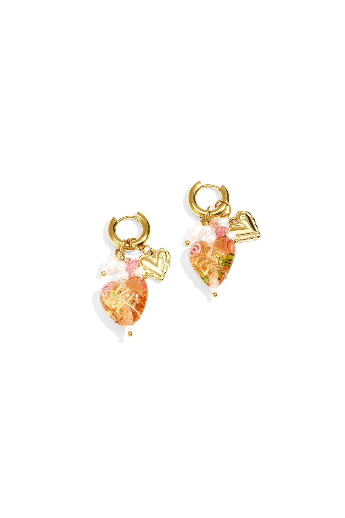 Pair of gold hoop earrings with peach-colored heart charms decorated with floral details, pearl accents, and gold mini hearts on white background