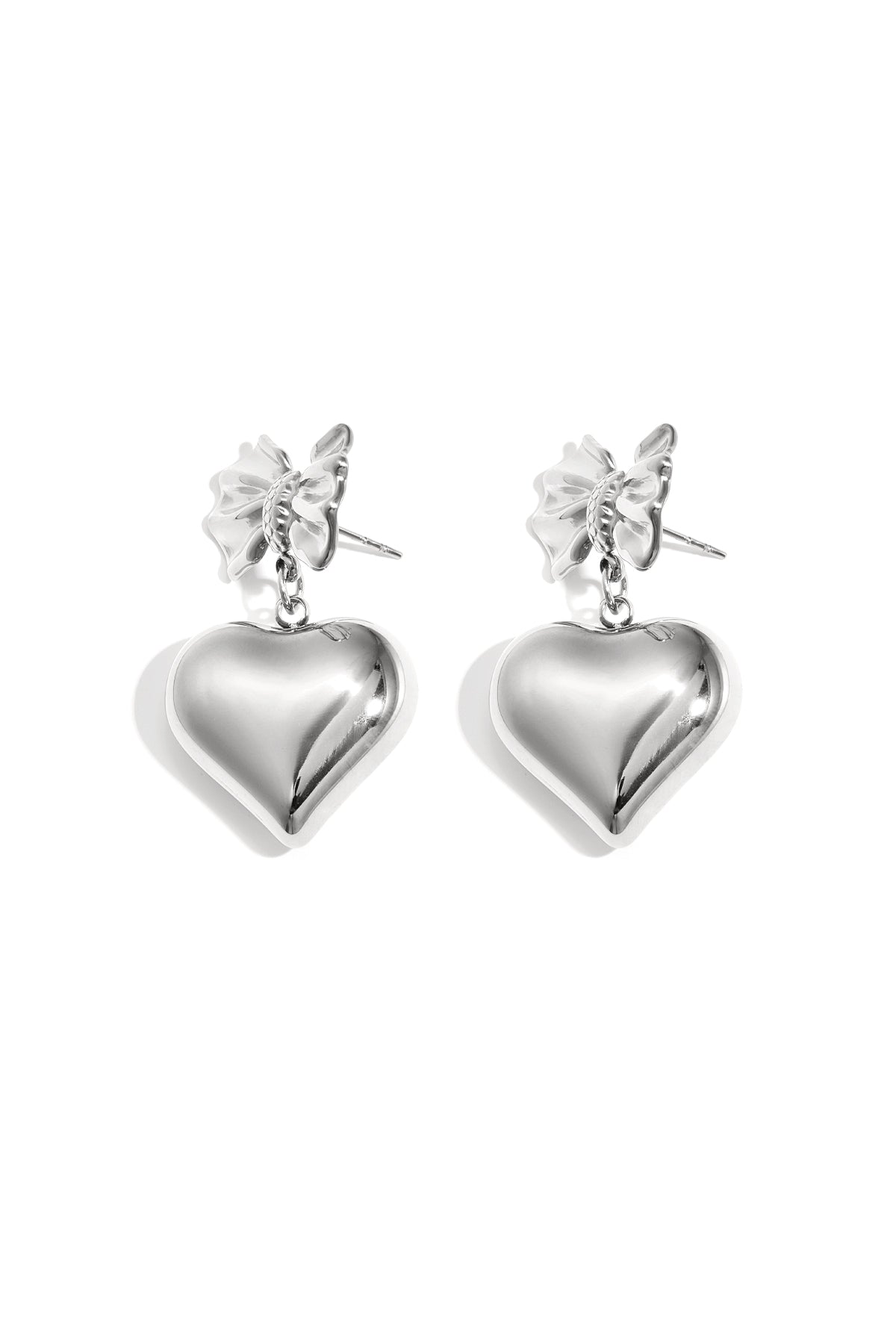 Silver version of bow and heart drop earrings shown on white background