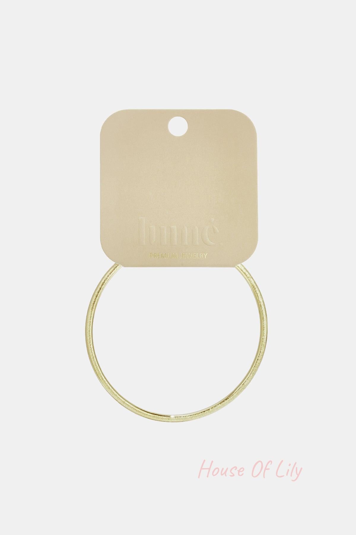 Ultra Slim gold-tone circle bangle with a textured finish, displayed on a branded display card.