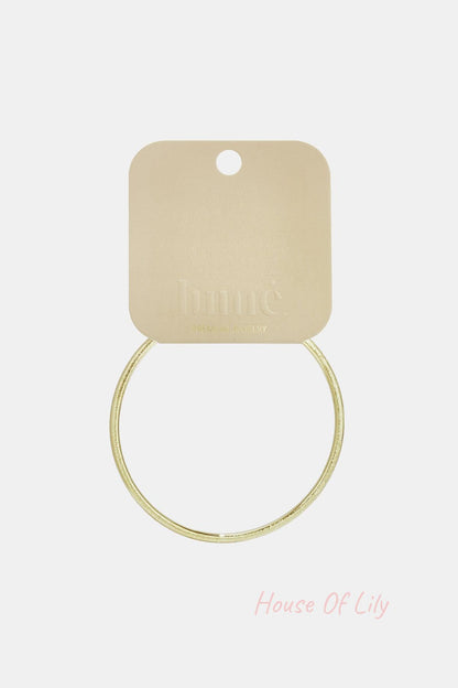 Ultra Slim gold-tone circle bangle with a textured finish, displayed on a branded display card.
