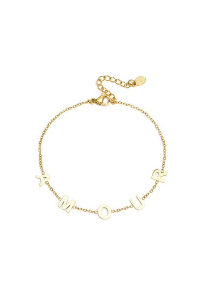 Gold chain bracelet with the letters A M O U R spaced evenly across a delicate link chain and adjustable lobster clasp
