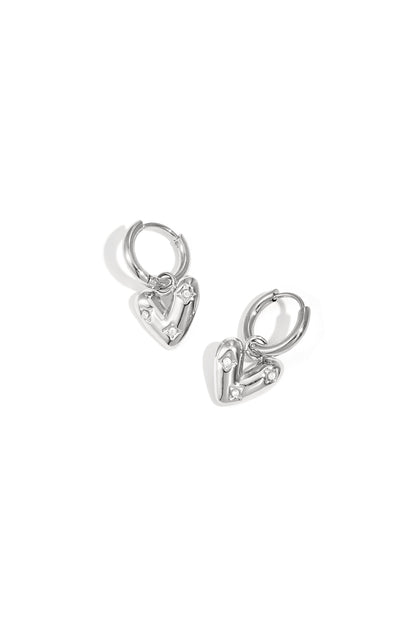 Silver heart charm hoop earrings with small zirconia stones on a white background