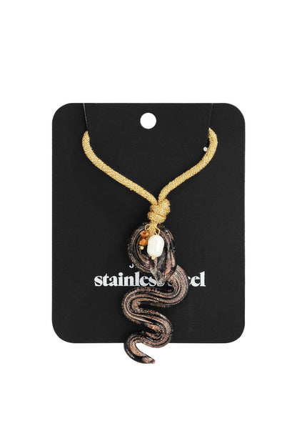 Sss-Tier Snake Vibe necklace features a glass snake pendant in black and copper, accented with a white pearl on gold cord.