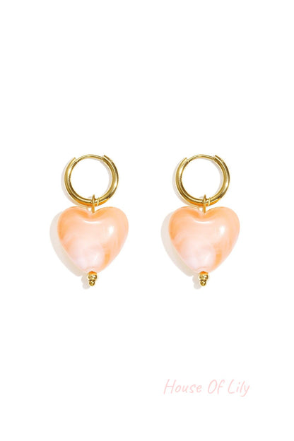 Y2K gold hoop earrings featuring marbled peach-colored heart charms with a small gold bead detail.