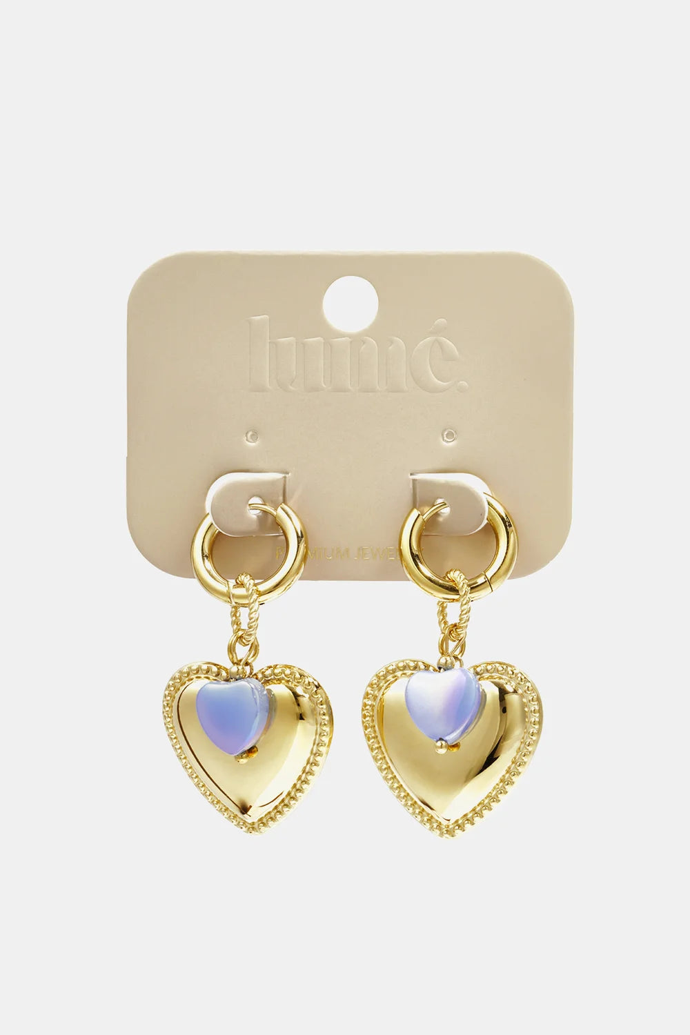 Gold-tone drop hoop earrings featuring polished heart charms with iridescent, lavender-tinted center stone accents.