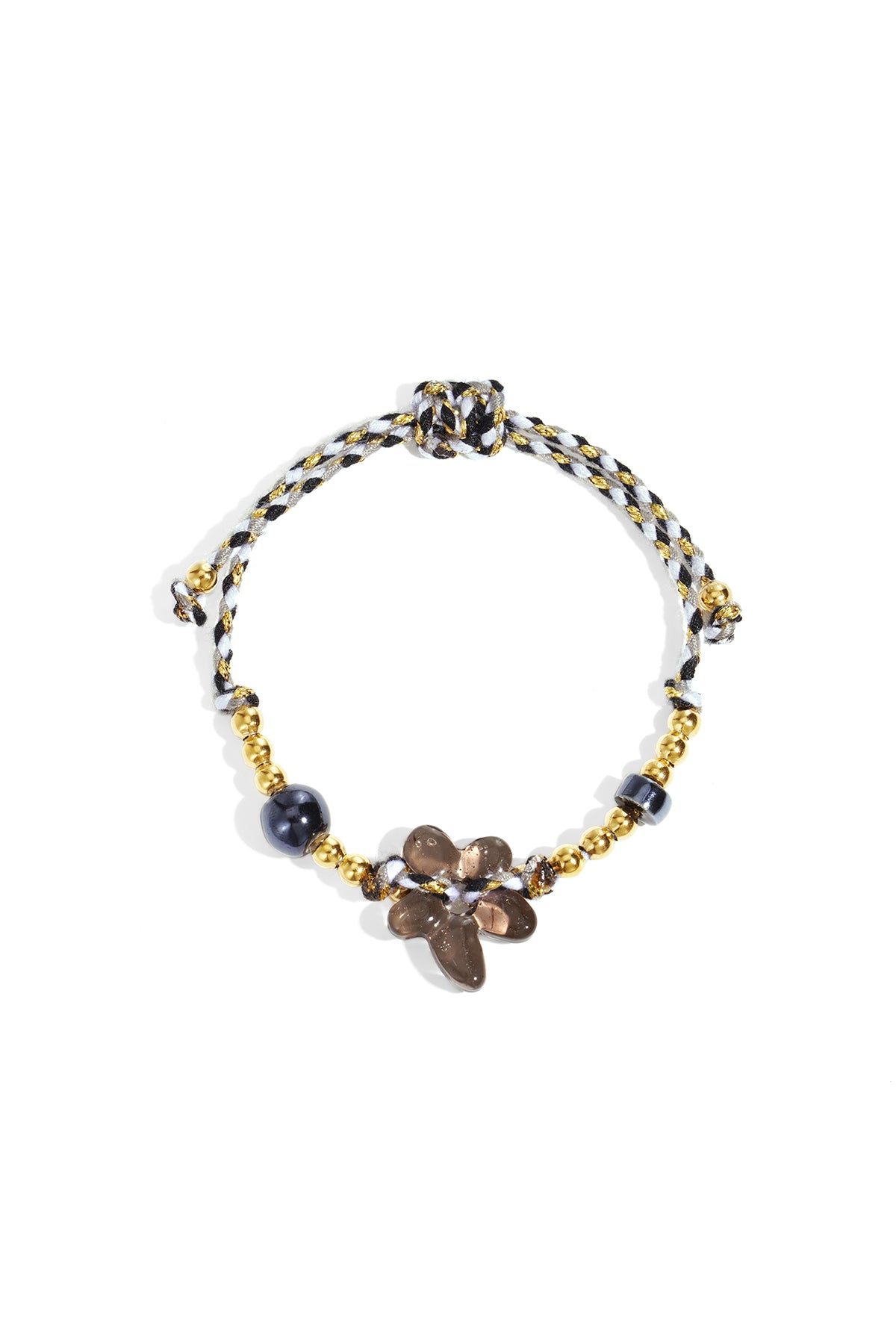 Black and white braided bracelet with gold beads and a brown flower-shaped glass bead on white background