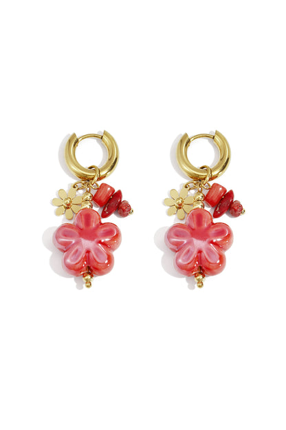 Pair of gold hoop earrings with vibrant red-pink floral resin charms and complementary beads on white background