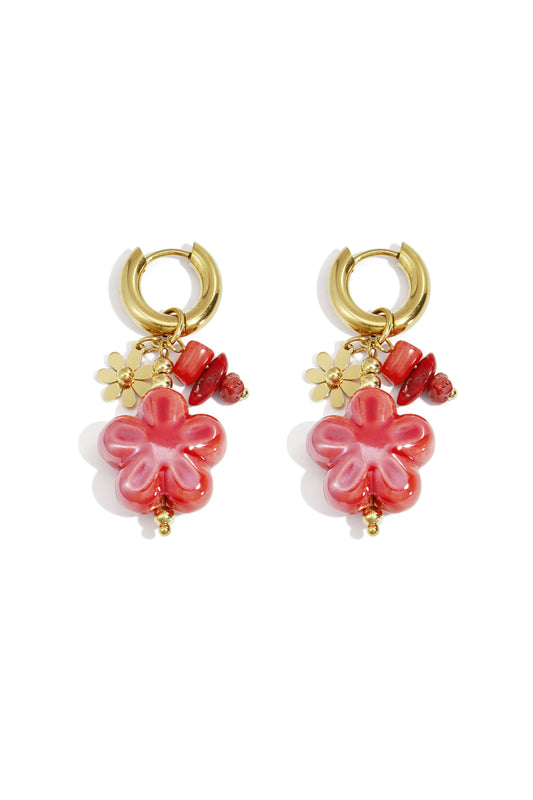 Pair of gold hoop earrings with vibrant red-pink floral resin charms and complementary beads on white background