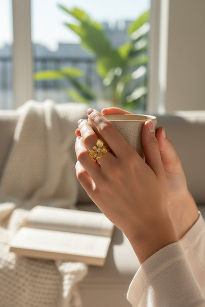 Gold Flower Accent ring featuring a delicate textured petal design with a central sparkling stone, worn on a finger.