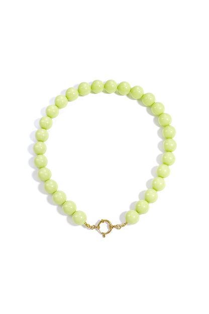 Chunky pastel yellow resin beaded necklace with gold clasp on white background