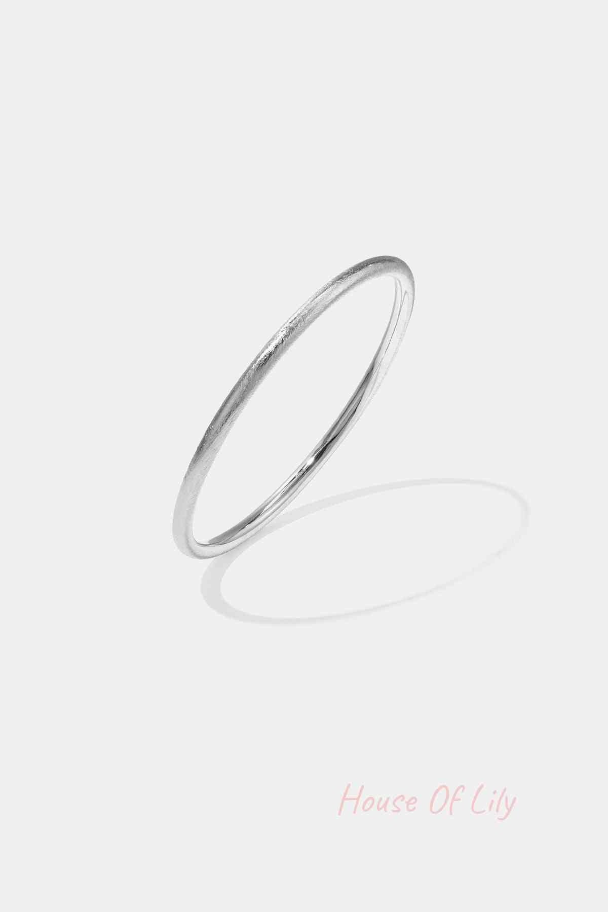 Minimalist silver circle bangle with a soft texture on white background