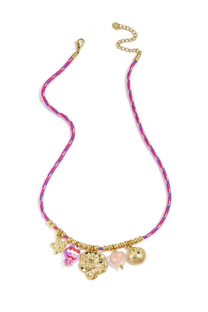 Pink rope necklace with gold beads and five charms including flower, fish, heart, star, and shell on a white background
