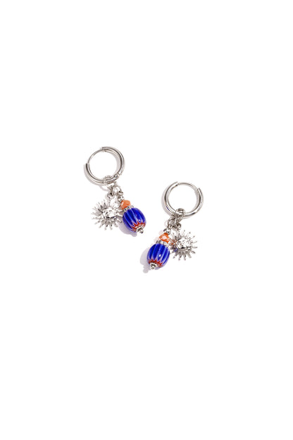 Silver tone hoop earrings featuring sun charms and blue-orange glass beads on white background