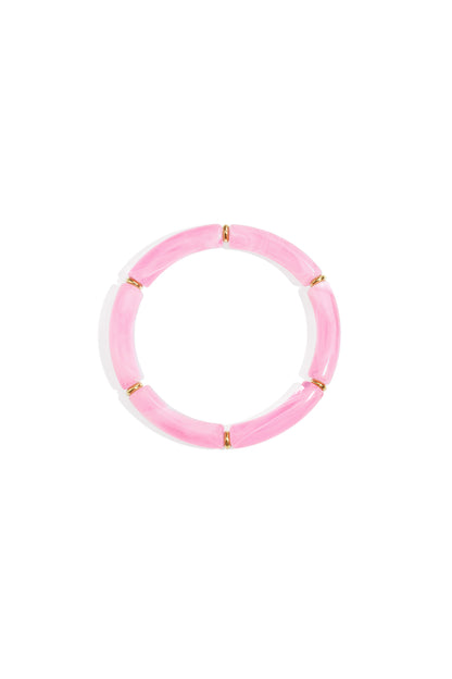 Soft baby pink resin tube bracelet with gold-tone ring spacers on white background