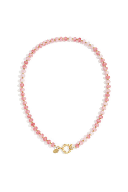 Close-up of a purple stone beaded necklace with gold beads and toggle clasp