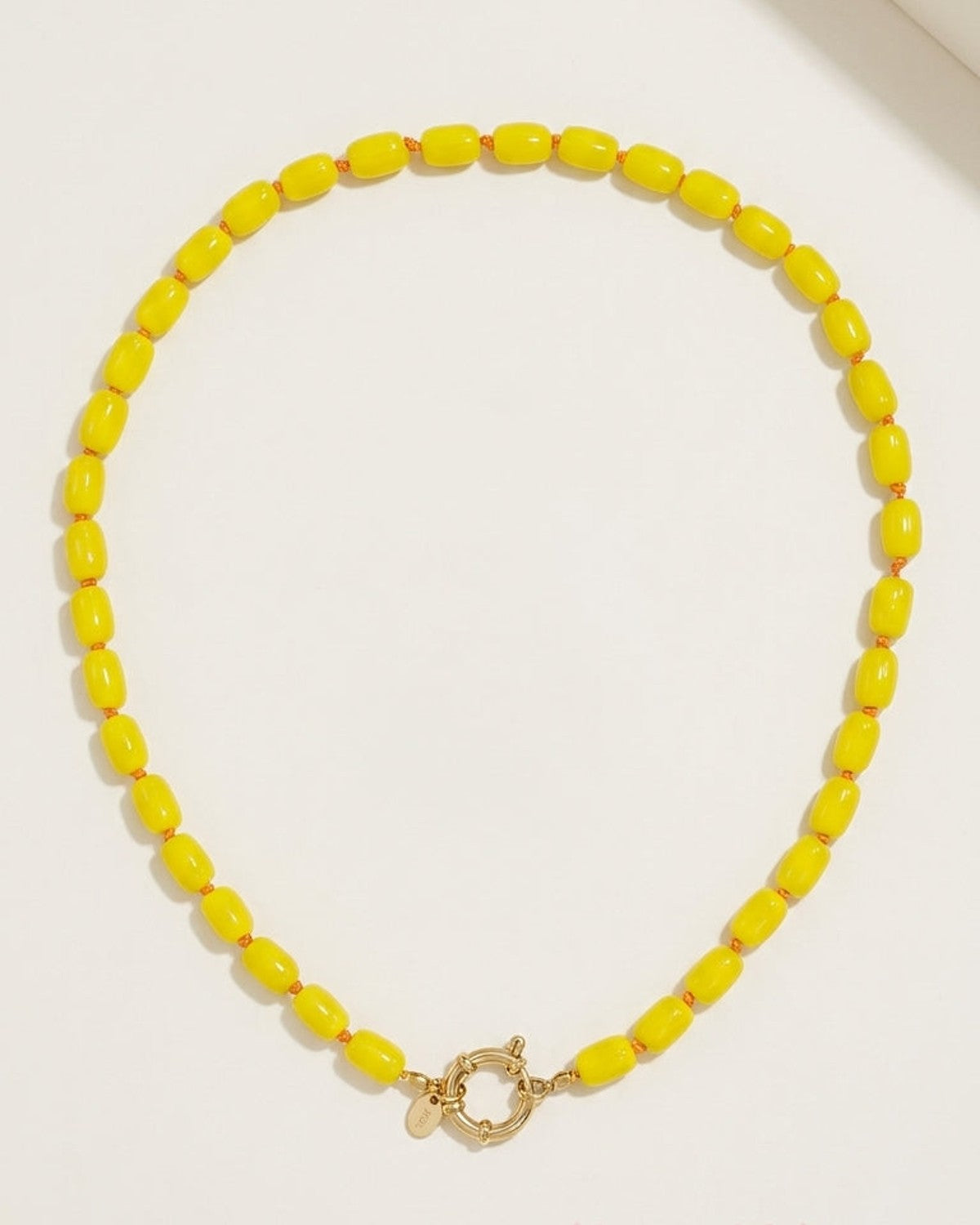 A yellow beaded necklace with cylindrical beads and a gold-colored clasp.
