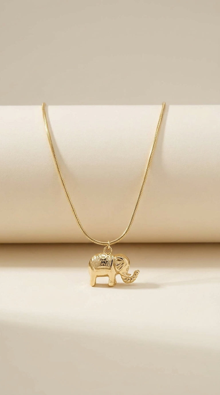Polished gold-finish necklace featuring a detailed elephant pendant on a thin snake chain.